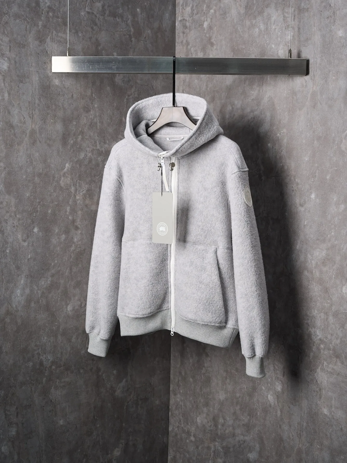 P780 Actual hanging auction] CANADA GOOSE/Canada Goose Chilliwack white label wool fleece hooded jacket [Ready stock] S M L XL Fabric selection: Wool fleece fabric made of wool as the main body and a very small amount of spandex and polyester fiber blended. Wool is a core natural ingredient that provides unparalleled temperature regulation, antibacterial and anti-odor properties and a skin-friendly feel. The feeding of a small amount of spandex gives the fabric a certain degree of four-way elasticity, making it non-restrictive during daily activities. As the basis of fleece's structure, polyester fiber enhances the fabric's durability, wrinkle resistance and quick-drying properties. It contributes to the loft of the fleece and provides functions such as trapping air.  Detail 1: The sleeves and hem are closed with 2×2 ribbing. Its strong elasticity can closely fit wrists and waists of different thicknesses, forming an effective 'seal' to prevent cold wind from blowing back. It can still maintain its original shape after repeated stretching and use, and is not easy to loose and deform. And the ribbed cuffs can convey a sense of design and enhance the visual beauty.  Detail 2: The combination of hood design and elastic buckle improves warmth and windproof performance when wearing.